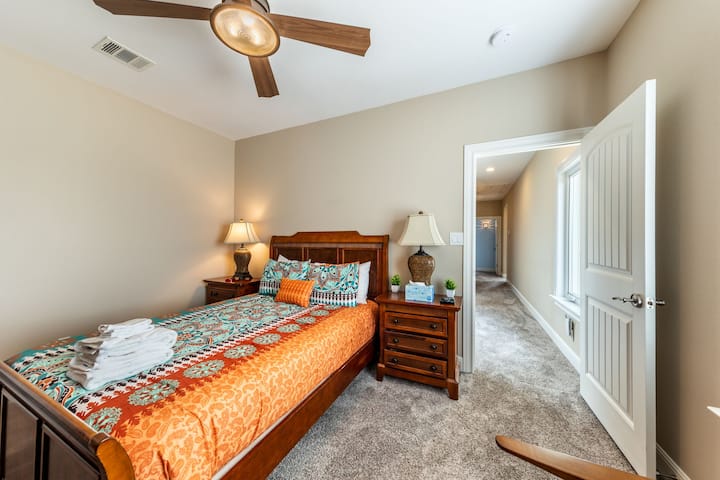 غرفة نوم جذابة مع منسوجات نابضة بالحياة ومناضد سرير ومدخل مدخل مرفق.