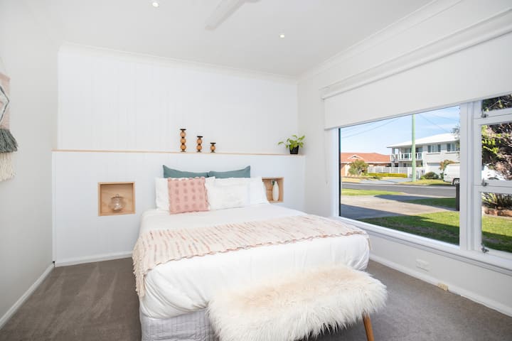 Un dormitorio secundario lleno de luz con una cómoda cama tamaño queen y una nueva alfombra de lujo para tu comodidad.  Las ventanas se han actualizado con persianas 100% bloqueadas para el sueño perfecto todas las mañanas.