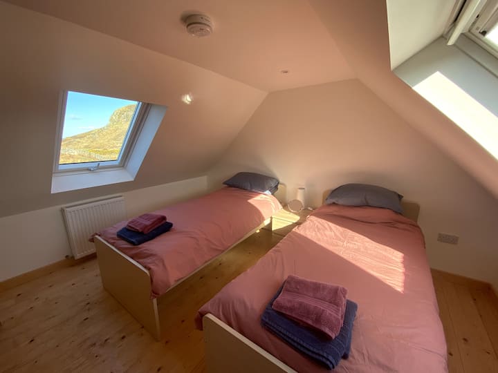 Საძინებელი ორი ერთადგილიანი საწოლით, გარდერობითა და საწოლის გვერდით ნათურებით.