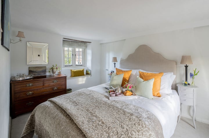 Красиво светла, двойна спалня с ръчно изработено двойно легло. Меко дизайнерско спално бельо и достатъчно място за съхранение с вградени гардероби и античен скрин.