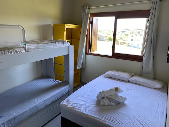 חדר עם מיטה זוגית ומיטת קומתיים לילדים.