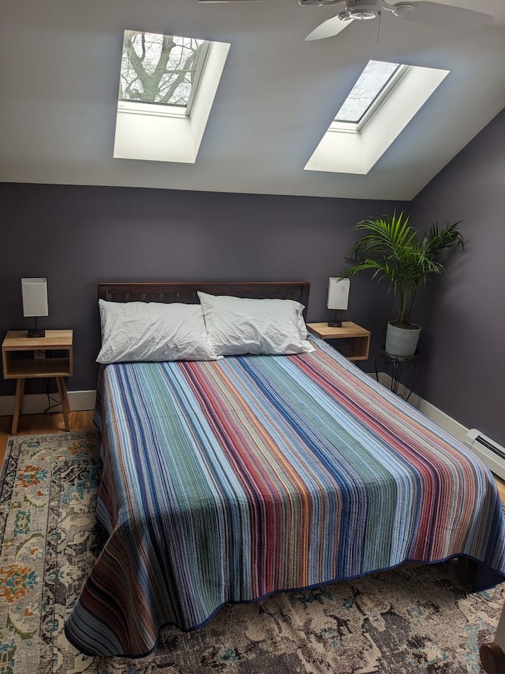 Një krevat dopio "queen" në dhomën tonë të dytë të gjumit, i cili ka të gjitha të njëjtat shërbime: nuanca që errësojnë dhomën, stacione karikimi në çdo tavolinë anësore, batanije tepër të rehatshme.