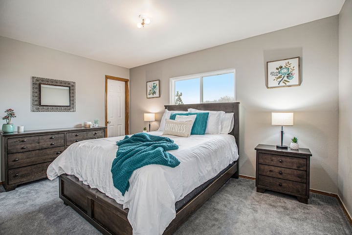 Útulná spálňa s manželskou posteľou na poschodí. V noci má táto izba tiež skvelý výhľad na mestské svetlá a útes cez cestu cez cestu cez deň. 