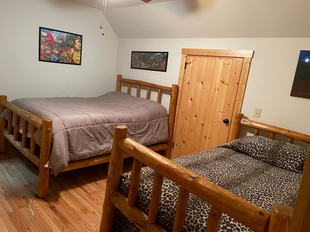 Twee  houten bedden, een grote en een eenpersoonsbed, en een grote kast met ruimte om te spelen in de 2e slaapkamer.