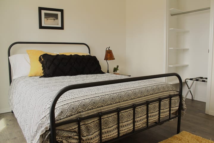 Სრული ზომის საწოლი კომფორტული ბამბის თეთრეულით და საკმარისი სივრცე კარადაში.