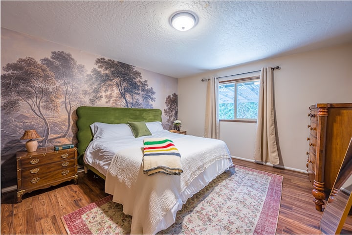 Chumba cha kulala cha msingi kilicho na kitanda cha ukubwa wa MFALME, matandiko ya chini, mapazia meusi, kabati la nguo kwa ajili ya kuhifadhia, kufikia ukuta hadi kwenye kabati.