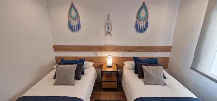 Chumba cha kulala mara mbili, chenye vitanda viwili vya mtu mmoja na kabati lililojengwa ndani.