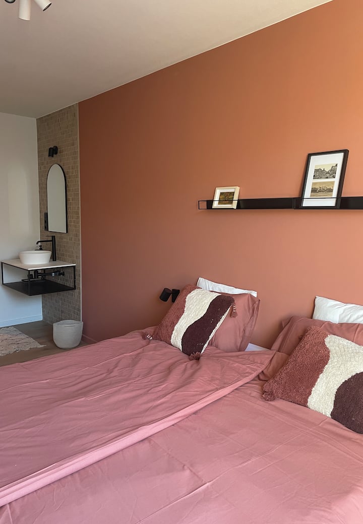 Rode slaapkamer: kingsize bed, opbergruimte met kledingkast, badkamer met douche.
