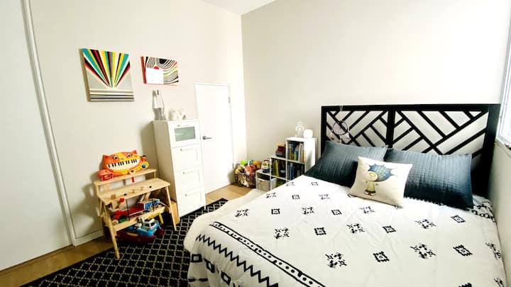 Grand lit. Bureau pour enfants et jouets et livres bien rangés.
