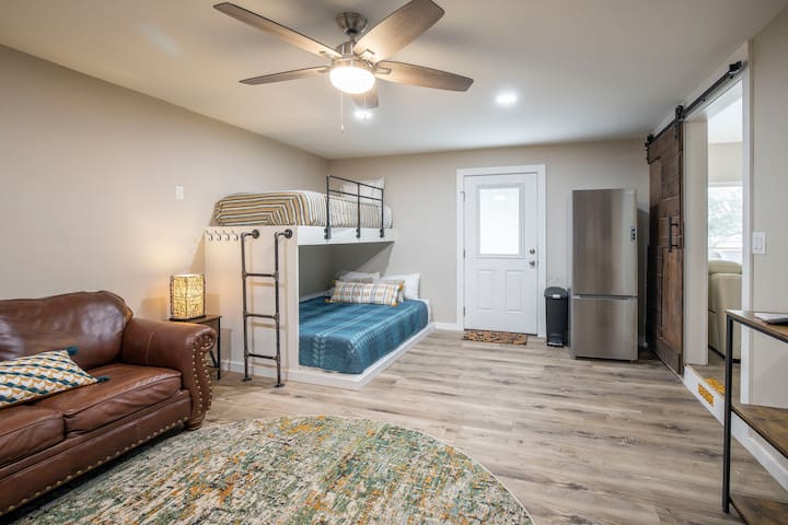 Main house:   Bunk Room (view 2).  Custom built twin over Queen bunks, small couch, TV.  A sliding barn door separates the bunk room from the living room.  Has a regular sized refrigerator.  (Main house has 2 refrigerators and 2 hot water heaters)