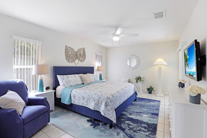 Amplio dormitorio principal con una lujosa cama tamaño king, decoración costera, televisor inteligente y mucha luz natural. ¡Incluye su propio baño privado para mayor comodidad y privacidad durante su estancia!