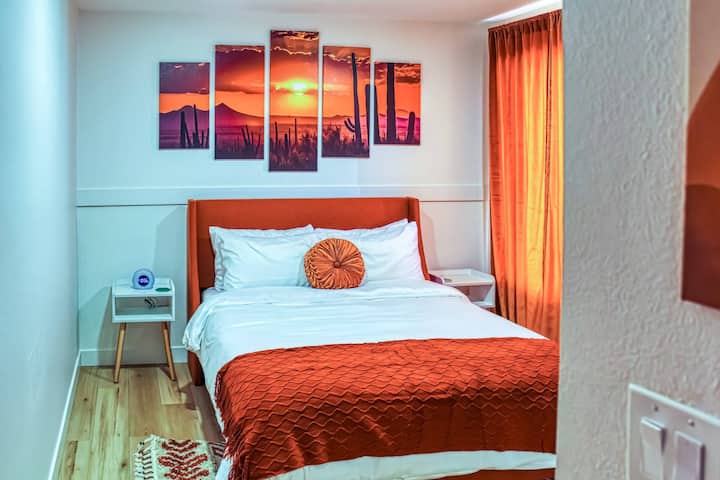 El dormitorio "Sunset" de Arizona, tiene una televisión inteligente y una cama tamaño queen. También tiene un escritorio plegable y una silla en el armario para cualquier persona que lo necesite.