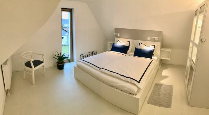 Chumba cha kulala kilicho na kitanda mara mbili (180 x 200), meza ndogo kando ya kitanda, taa za kusoma zinazoweza kupunguka na kabati la nguo lililoangaziwa (ikiwemo kidhibiti cha mbali)