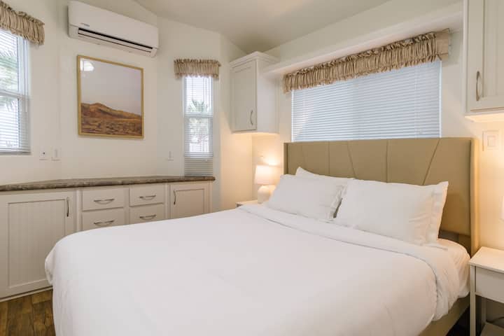 Dormitorio principal, con una cama tamaño queen y espacio de almacenamiento.