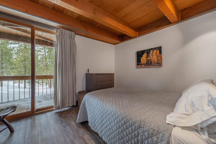 Dormitorio en la planta baja con cama tamaño queen nueva, suelo y muebles con vistas al patio privado. 