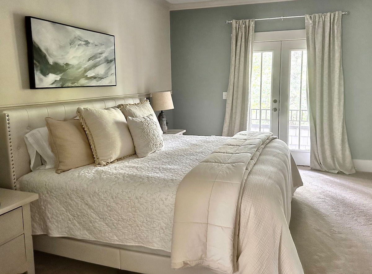 Dhomë gjumi kryesore me dyer franceze që të çojnë në një ballkon privat të katit të dytë. Një vend romantik për kafe në mëngjes ose pamje nga perëndimi i diellit!