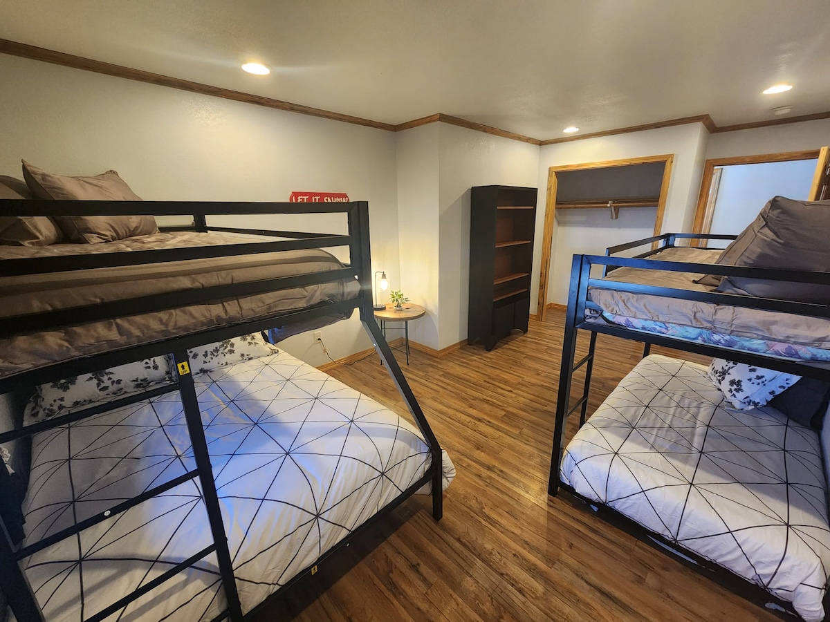 Habitación con literas con 1 cama de tamaño completo, 3 camas individuales y mucho espacio.