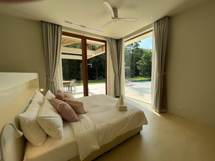 غرفة النوم 1 - غرفة نوم رئيسية مع باب منزلق إلى الفناء، في مكيف هواء في السقف وحمام خاص.