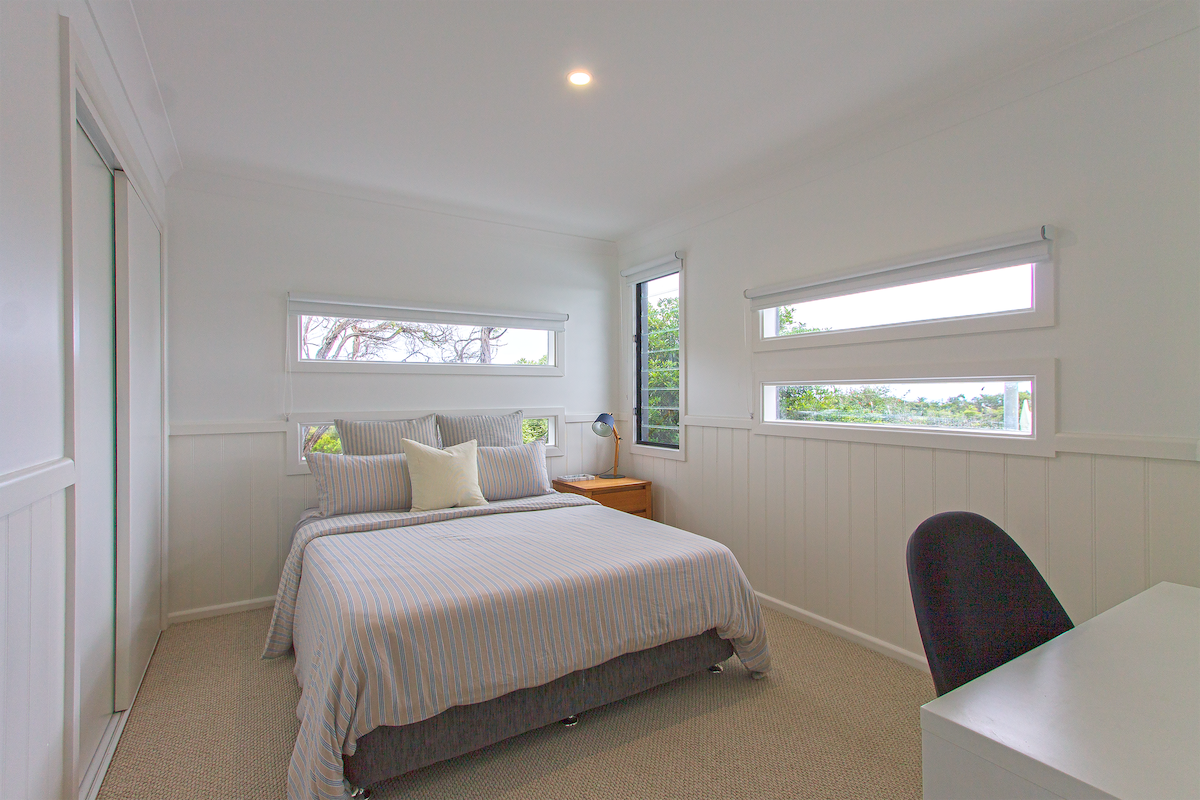 ห้องนอนที่ 2: มีแสงธรรมชาติบังม่านโต๊ะทำงานและเก้าอี้ 