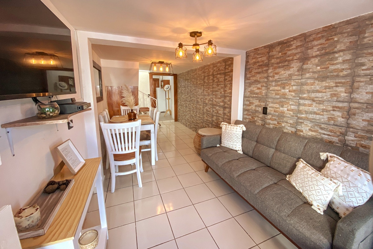 ห้องนั่งเล่นพร้อมโซฟาเบดสมาร์ททีวีพร้อมเคเบิลทีวีและ Wi-Fi ห้องรับประทานอาหารและทางเข้าครัว