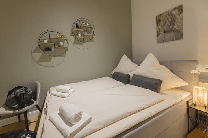 卧室配有双人弹簧床、边桌和带天鹅绒椅的桌子。 为每张预订的床铺提供毛巾套装和干净的床上用品。