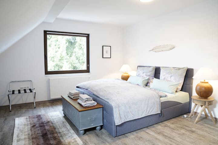 Baada ya siku ndefu na yenye matukio katika Msitu wa Thuringian, chumba chetu kikuu cha kulala ndicho mahali pa kuweka kichwa chako kilichochoka. Inachanganya fanicha maridadi, starehe na utendaji. 