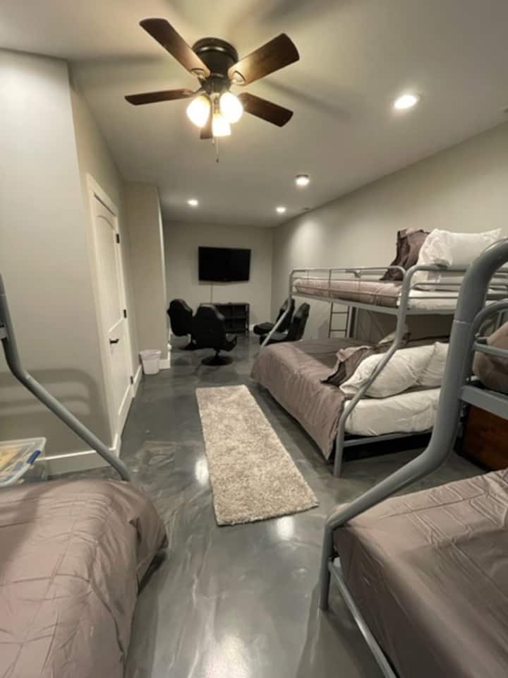 Chambre superposée au sous-sol avec coin vidéo de jeu.  La chambre dispose de trois (3) lits jumeaux sur des lits superposés complets