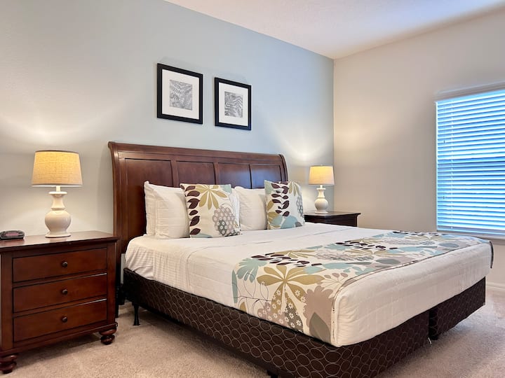 Брачна спална соба осветлена од сонцето со удобен декор и удобен кревет.