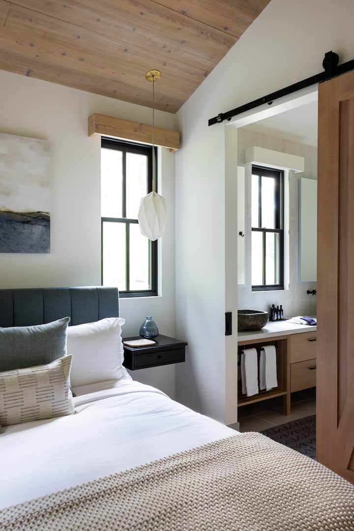 غرفة نوم مع حمام خاص مليء بأساسيات الحمام العضوية