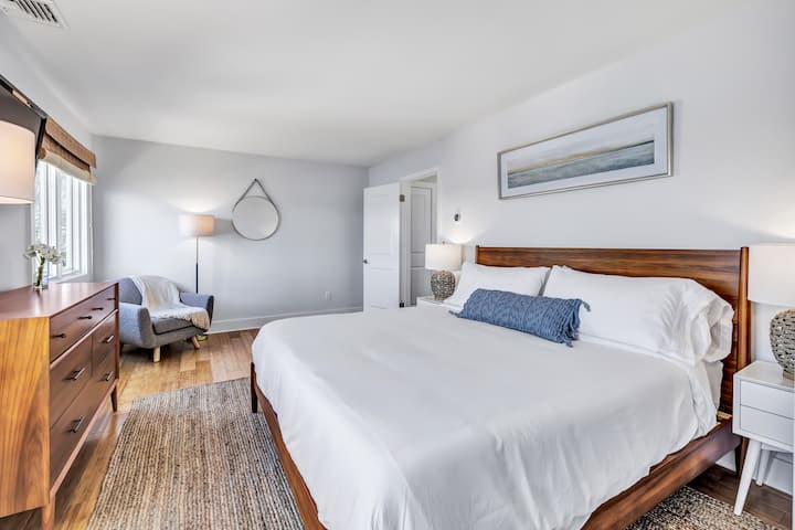 Kingsize-Schlafzimmer mit Tempur-Pedic-Matratze, West-Elm- und Artikelmöbeln und vollem Blick auf das Milford-Wasser