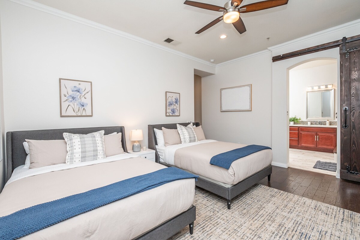 ห้องนอน #5- ห้องสวีทพร้อมเตียงควีนไซส์ 2 เตียงสมาร์ททีวีและห้องน้ำโต๊ะเครื่องแป้งคู่เครื่องเป่าผมอ่างอาบน้ำและฝักบัวอาบน้ำ ประตูบานเลื่อนเปิดไปยังลานบ้านและพื้นที่นั่งเล่น