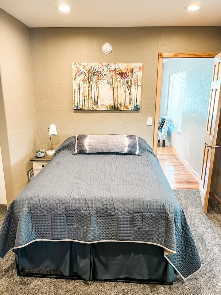 Una cama de matrimonio, ubicada en el nivel principal.  Este dormitorio tiene una puerta con acceso al único baño del nivel principal.