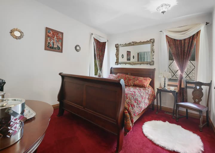 Queen Suite- This roomy suite features a queen size sleigh bed, built in closet with shelving, gorgeous mirrors and tapestries, Tiffany lamps/lighting, a sitting area, tea service, and spa robes.