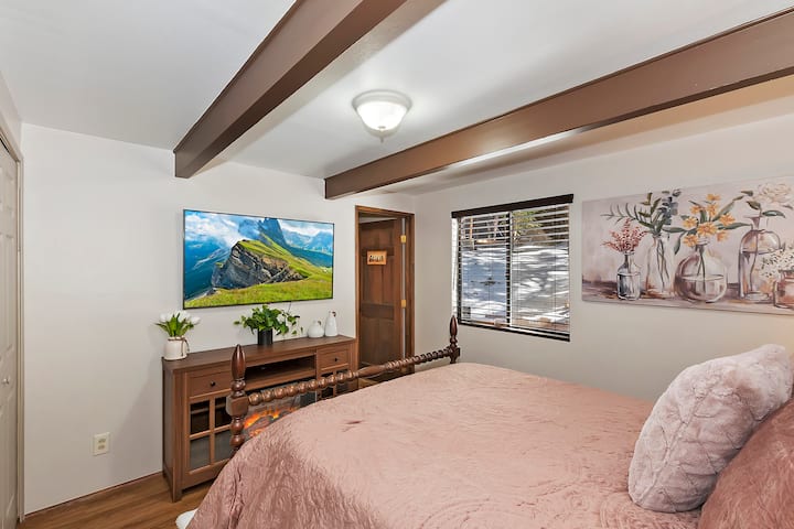 Спална соба на првиот кат покрај трпезаријата со брачен кревет со 4 столбови, електричен камин, 60-инчен паметен телевизор и сопствена бања со туш.