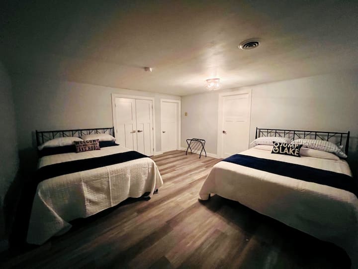 Chumba cha kulala cha kiwango cha chini na vitanda (2) vya ukubwa wa malkia; dawati liko katika chumba hiki cha kulala.