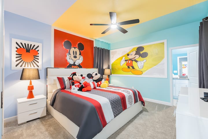 ¡Adéntrate en el mundo de Mickey en este divertido refugio! Las paredes de color azul cielo brillante y amarillo soleado están enmarcadas por obras de arte de Mickey en rojo y naranja llamativos, mientras que la elegante ropa de cama gris destaca con los clásicos peluches de los personajes.