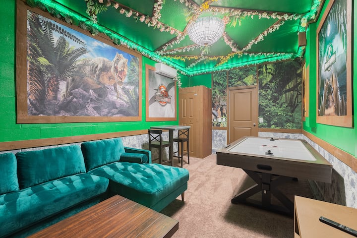 Entra en esta sala de juegos jurásica, donde exuberantes enredaderas de LED cubren un techo de un verde vibrante, mientras que imponentes murales de T-rex rugen por las paredes. Desafía a tus amigos a jugar al hockey de aire, relájate en el lujoso sofá verde azulado: ¡tu paraíso prehistórico de juegos te espera!
