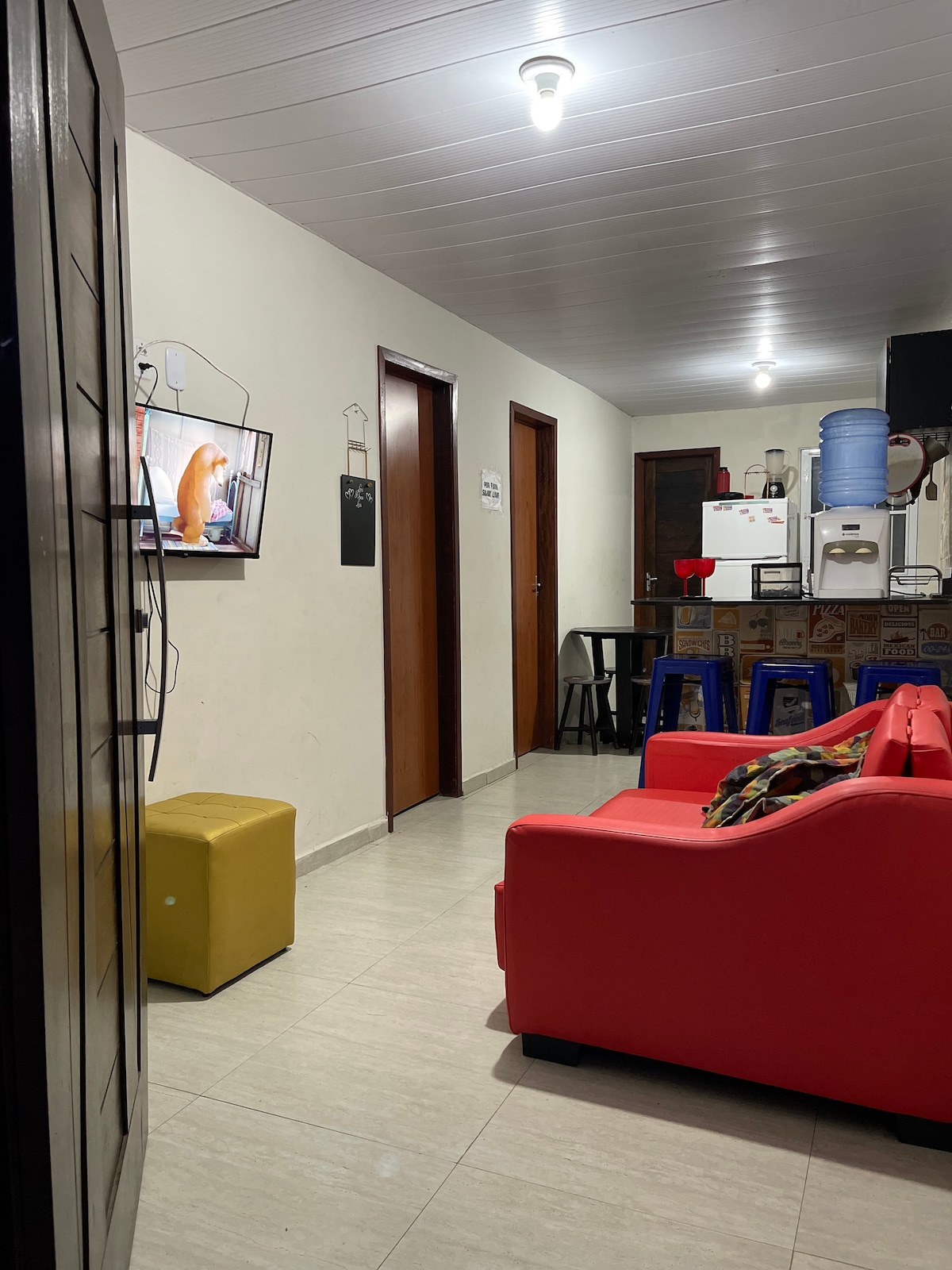 Соба со паметен телевизор, кауч на спуштање и фотелја на баба. 