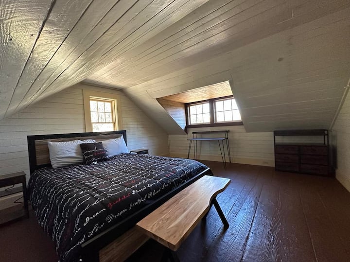 Este es el tercer dormitorio de arriba, a la izquierda de las escaleras. Cuenta con cama queen size. Las dos ventanas más grandes de la derecha tienen hermosas vistas a la bahía. La ventana en el centro tiene vistas de los muchos árboles grandes en la parte posterior.