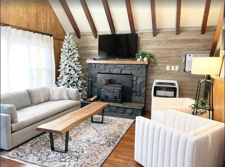 Beautifully designed living room with very comfortable sofa (West Elm), swivel chairs, large Roku TV, and wood burning fireplace ( wood provided) await you and your family for a holiday season at the Poconos!