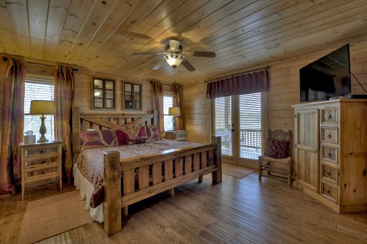 La chambre principale King est au premier étage et dispose d'un ventilateur de plafond, d'un bureau idéal pour votre ordinateur portable, d'une télévision à écran plat, d'une vue sur la rivière et de portes-fenêtres menant au porche principal.