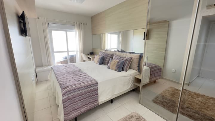 Აპარტამენტი 1 დიდი ზომის ორადგილიანი საწოლით, რომელიც მდებარეობს მეორე სართულზე, ტელევიზორით, კარადით, მაგიდით საწოლის გვერდით სკამით. 