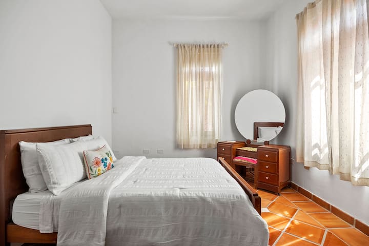 Dormitorio tranquilo con una cómoda cama completa y muebles clásicos.