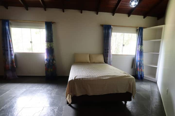Room on the 1st floor, with double bed and front view of the house 