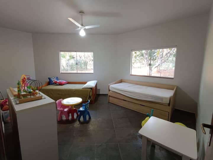 Bedroom 4. Bedroom with 2 single beds, auxiliary bed and children's toys. View to the side of the house.