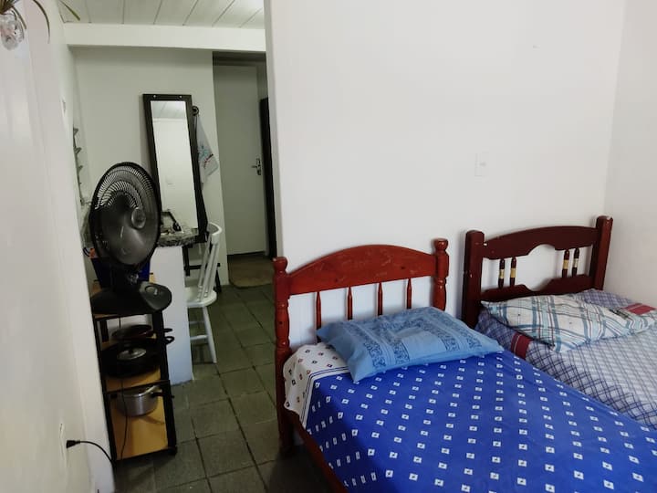 Predná strana s dvoma lôžkami a výhľadom na kuchyňu. 
Od vchodu do kuchyne nie sú žiadne dvere. 
V pozadí je možné vizualizovať dvere, otvorené, kúpeľne. 
Ventilátor je na príborníku hrnca, pred stoličkou je umývadlo a sporák.