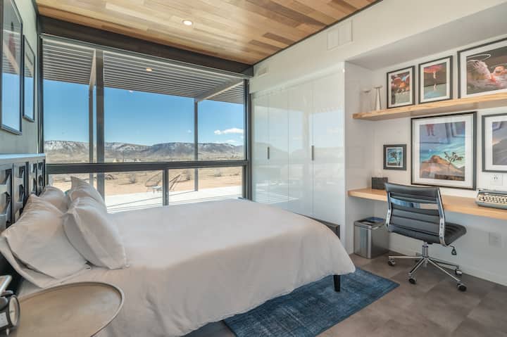 Queen Bedroom with floor-to-ceiling windows that has transparent shade & blackout shade. 