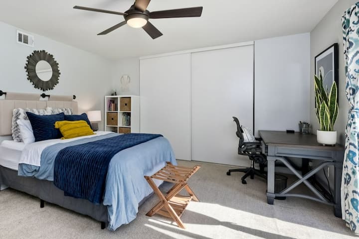 Izba s manželskou posteľou, televízorom a pracovnou stanicou. Priamy prístup a výhľad na zadný dvor.