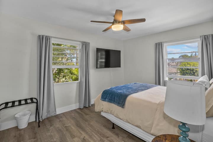 Dormitorio 1 con portaequipajes y TV inteligente de 55pulgadas y mesitas de noche.