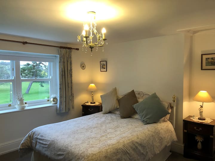 Veľká spálňa s manželskou posteľou s fantastickým výhľadom na dedinskú zeleň (zvlnený strom)